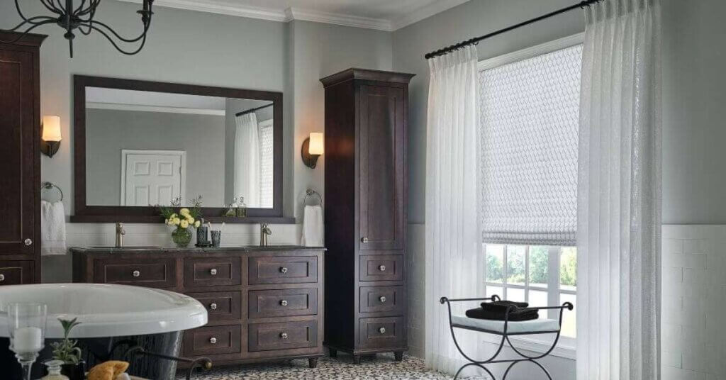 For bathrooms with better ventilation or less exposure to direct moisture, Roman shades in treated, moisture-resistant fabrics can bring softness and elegance.